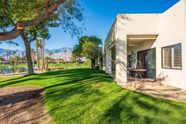 view of yard with a patio area and a water and mountain view