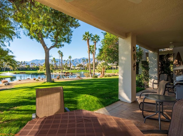 view of patio / terrace featuring a water and mountain view