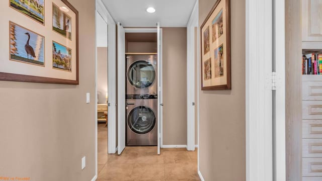 corridor featuring light tile patterned flooring and stacked washer / dryer