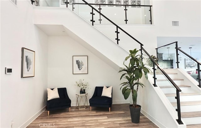 sitting room with wood-type flooring and a high ceiling