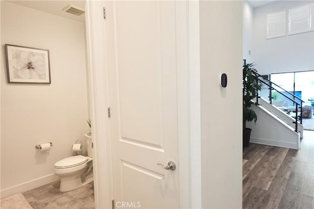 bathroom with hardwood / wood-style floors and toilet