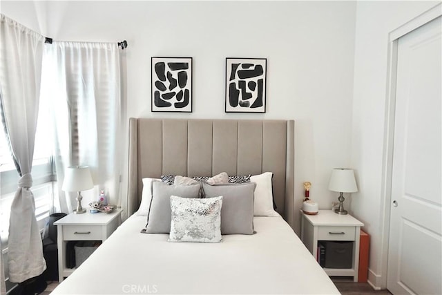 bedroom with dark hardwood / wood-style floors and a closet