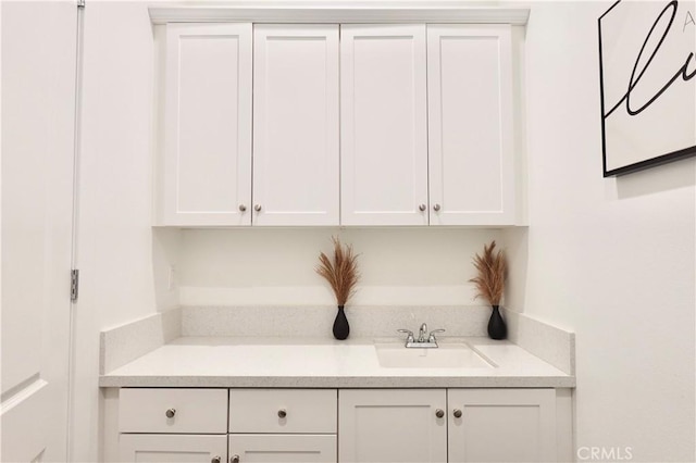 bar featuring white cabinetry and sink