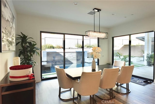 dining room with wood-type flooring and an inviting chandelier