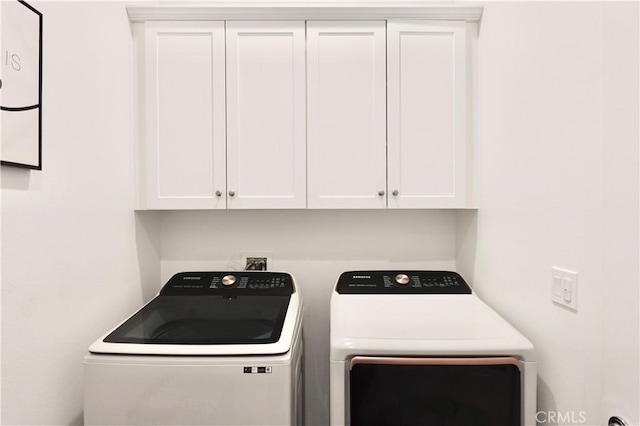 washroom with cabinets and washing machine and dryer