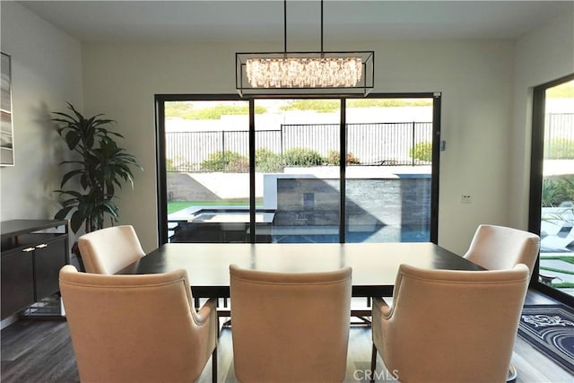 dining space featuring a chandelier, a healthy amount of sunlight, and hardwood / wood-style flooring