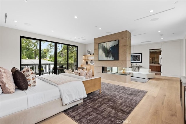 bedroom featuring access to exterior and light hardwood / wood-style flooring