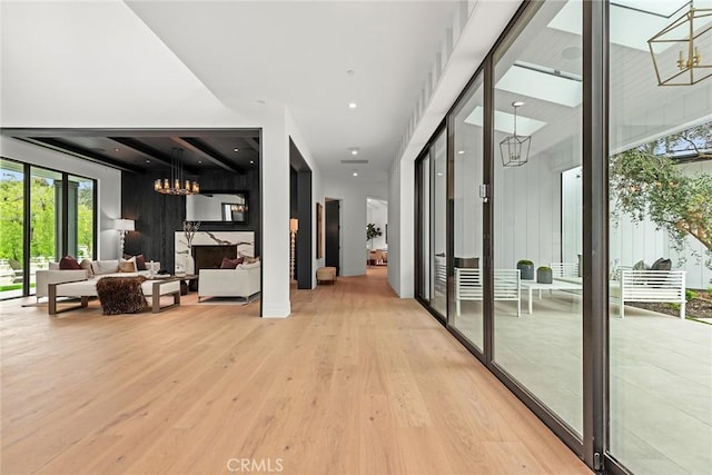 hallway with french doors, light hardwood / wood-style flooring, and a notable chandelier