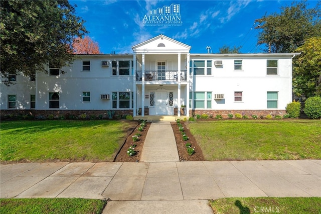 view of front of house featuring a balcony and a front yard