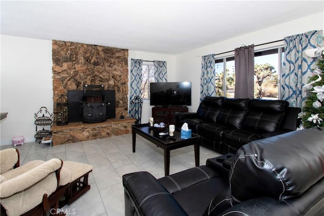 living room with light tile patterned floors and a wood stove