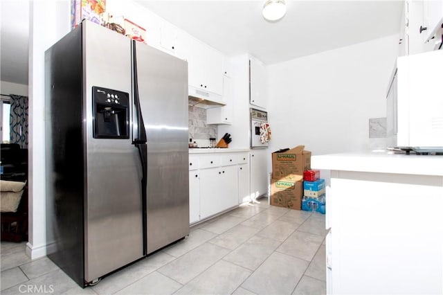 kitchen with white cabinetry, tasteful backsplash, wall oven, stainless steel fridge with ice dispenser, and light tile patterned floors