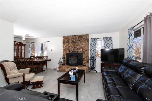 living room featuring ceiling fan and a wood stove