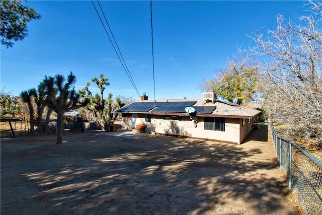 rear view of property with solar panels