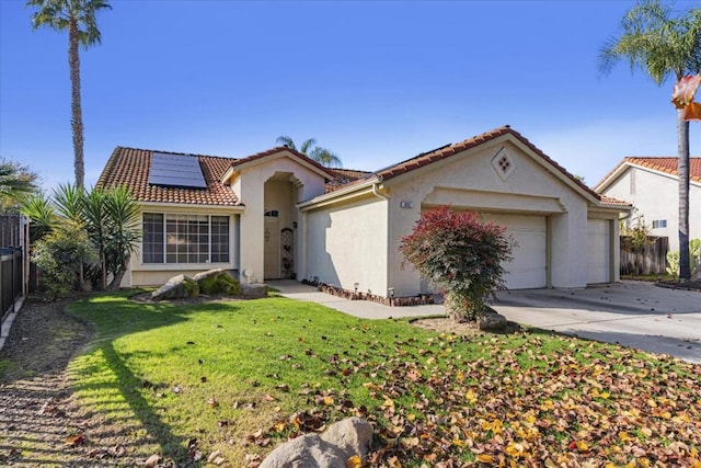 mediterranean / spanish home with solar panels, a garage, and a front lawn