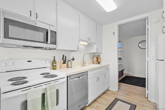 kitchen featuring white cabinets, stainless steel appliances, light hardwood / wood-style floors, and sink