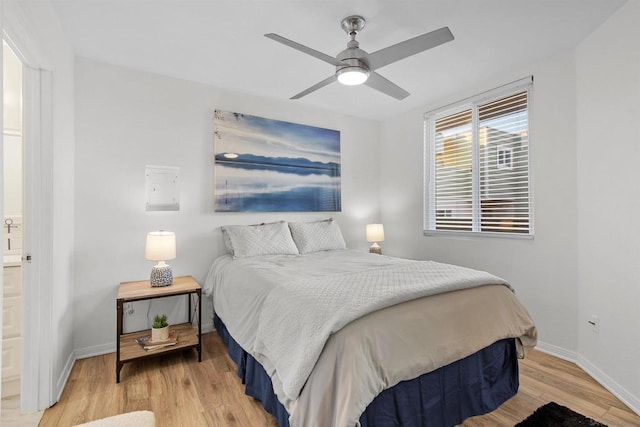 bedroom featuring light wood-type flooring, ensuite bath, and ceiling fan