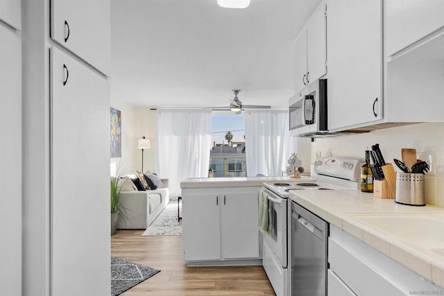 kitchen featuring white cabinets, ceiling fan, appliances with stainless steel finishes, and light hardwood / wood-style flooring