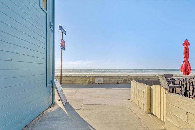 view of patio / terrace with a view of the beach and a water view