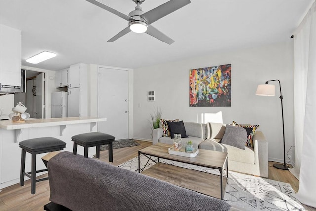 living room with light hardwood / wood-style floors and ceiling fan