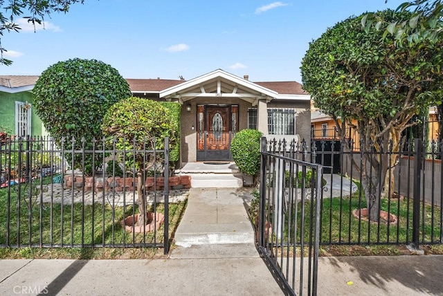 1417 W Gage Ave, Los Angeles, CA 90047 - bungalow-style house featuring stucco siding, a fenced front yard, and a gate