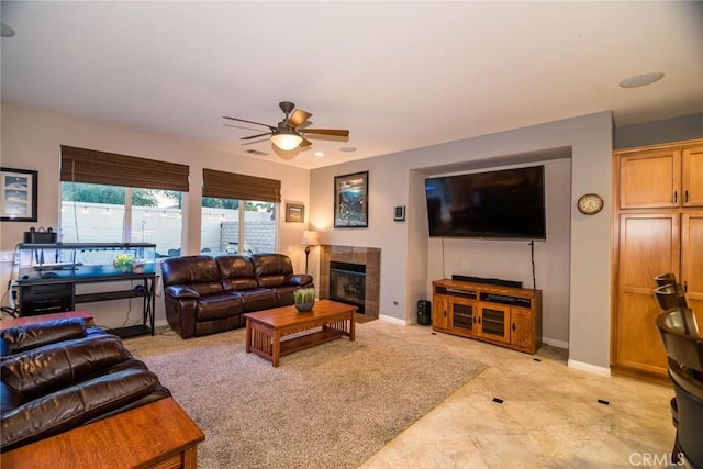 living room with ceiling fan and a fireplace