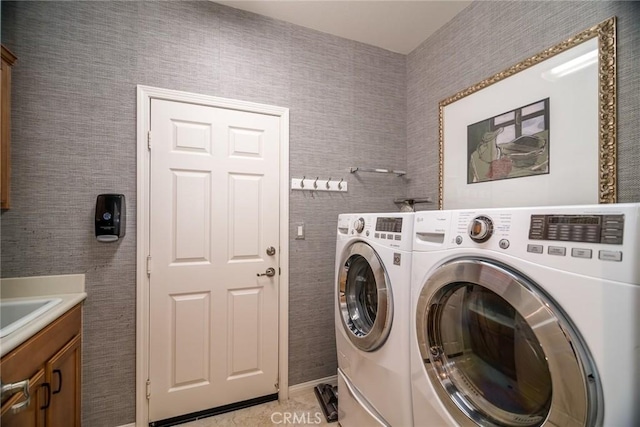 clothes washing area with cabinets, washing machine and dryer, and tile walls