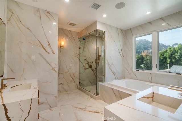 bathroom with separate shower and tub, tile walls, and sink