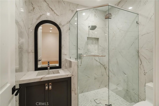 bathroom with vanity, toilet, and a shower with door