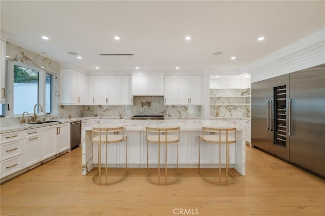 kitchen with a kitchen island, a kitchen bar, light stone countertops, and appliances with stainless steel finishes