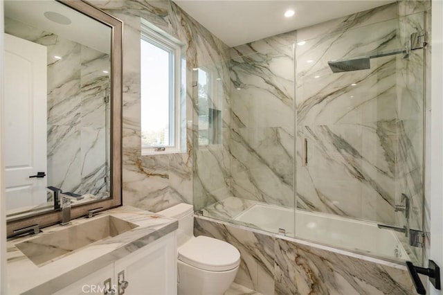 full bathroom featuring combined bath / shower with glass door, vanity, plenty of natural light, and tile walls