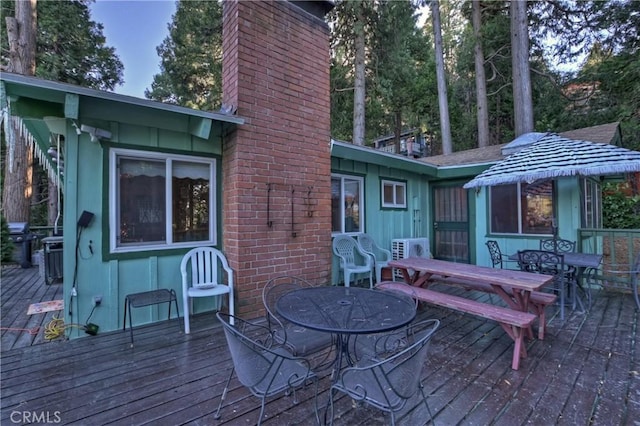 wooden terrace featuring a grill and ac unit