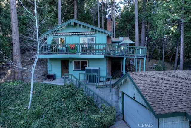 back of property with a garage and a deck