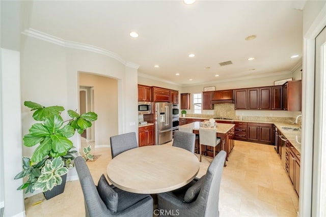 dining space featuring ornamental molding and sink