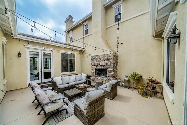 view of patio with an outdoor living space with a fireplace and french doors