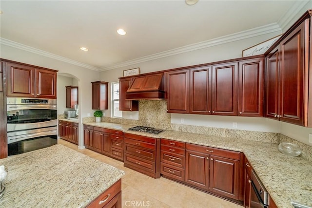 kitchen with custom range hood, stainless steel appliances, light stone counters, and ornamental molding