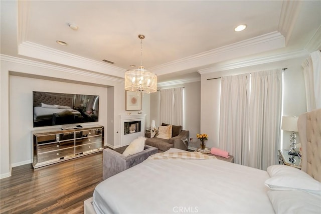 bedroom featuring dark hardwood / wood-style floors, crown molding, and a tray ceiling