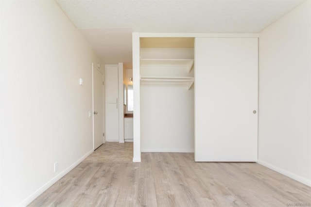 unfurnished bedroom with a closet and light hardwood / wood-style floors