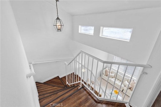 stairway with wood-type flooring and vaulted ceiling