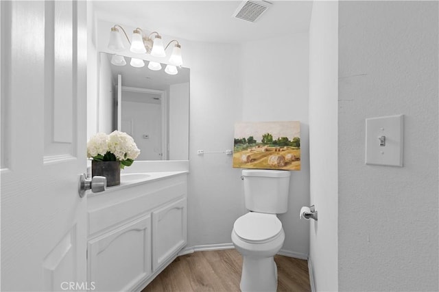 bathroom featuring vanity, hardwood / wood-style flooring, and toilet