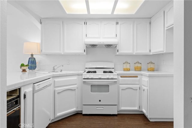 kitchen with white cabinets, white appliances, dark hardwood / wood-style floors, and sink