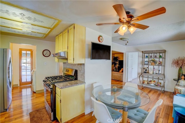 kitchen with ceiling fan, stainless steel appliances, and light hardwood / wood-style floors