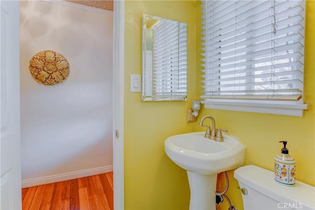 bathroom with sink, toilet, ornamental molding, and hardwood / wood-style flooring