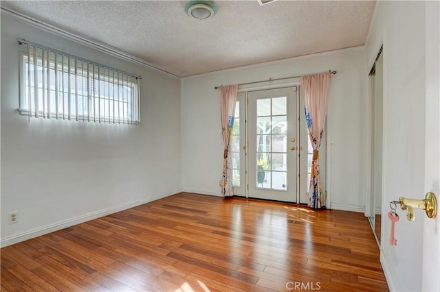 empty room with a textured ceiling and light wood-type flooring