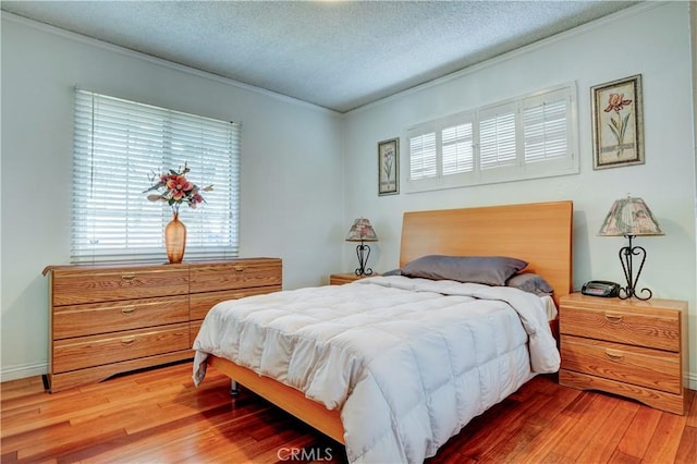 bedroom with hardwood / wood-style floors, crown molding, and a textured ceiling