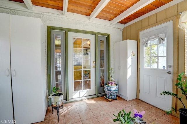 doorway to outside featuring light tile patterned floors, wooden ceiling, and beam ceiling