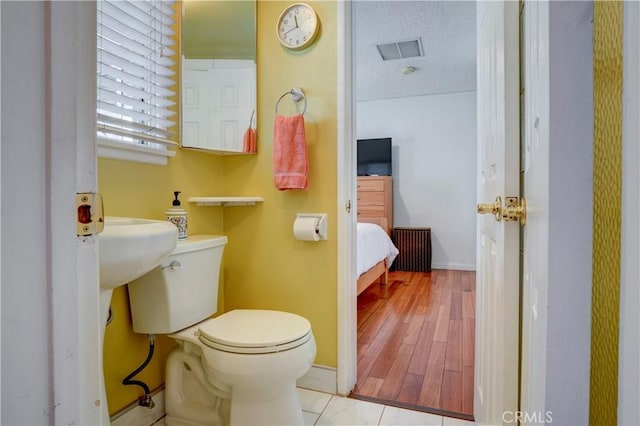 bathroom featuring toilet and wood-type flooring