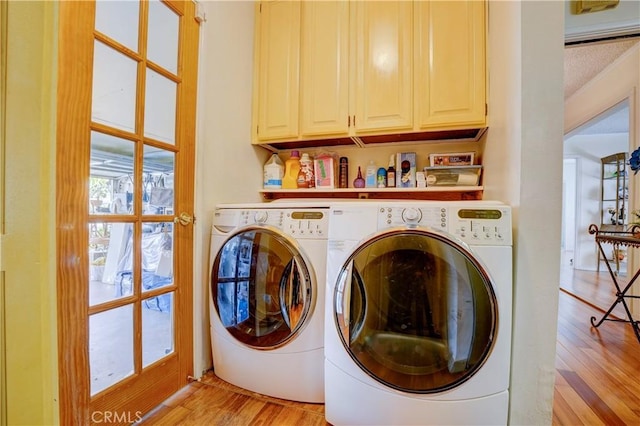 washroom featuring washer and clothes dryer, cabinets, a textured ceiling, and light wood-type flooring