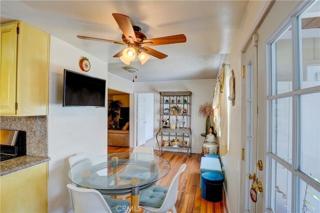 dining space featuring a textured ceiling, ceiling fan, and light wood-style flooring