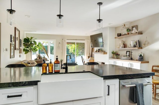 kitchen featuring sink, stainless steel dishwasher, white cabinetry, and pendant lighting