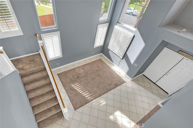 foyer with a high ceiling, light tile patterned floors, and a wealth of natural light